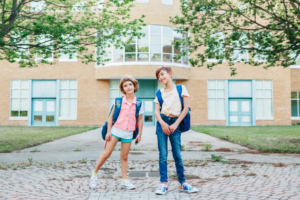 Kids children students sisters friends at school yard. Education, back to school in September autumn